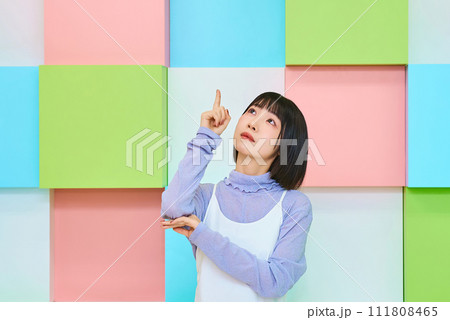 上の方を指す若い女性 111808465