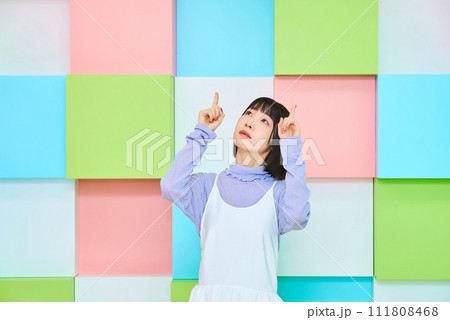 上の方を指す若い女性 111808468