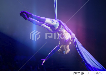 Performance by a circus acrobat artist. Girls perform aerial acrobatic elements on fabric. Performance by a circus acrobat artist. Girls perform aerial acrobatic elements on fabric. 111808766