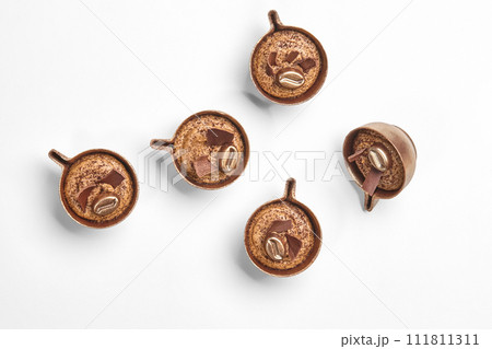Artisan chocolate coffee candies shaped as miniature cups 111811311