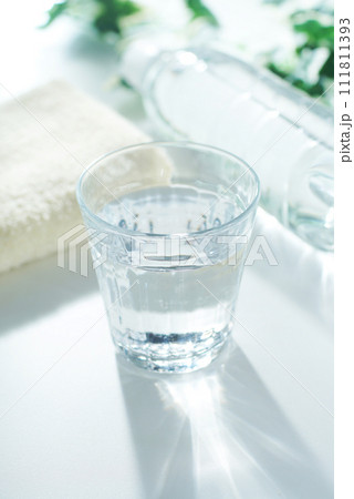 グラスに入った水とペットボトルとタオル 111811393