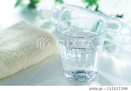 グラスに入った水とペットボトルとタオル 111811396