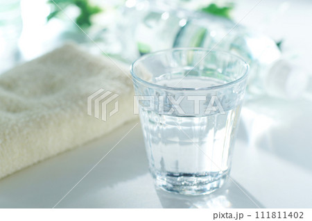グラスに入った水とペットボトルとタオル グラスに入った水とペットボトルとタオル 111811402
