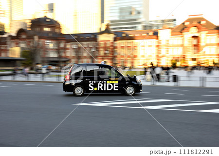 東京駅丸の内口前を走るタクシー 111812291