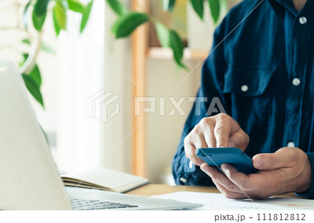 スマートフォンを操作する男性の手元 スマートフォンを操作する男性の手元 111812812