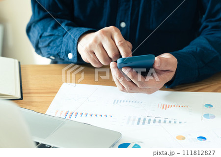 スマートフォンを操作する男性の手元 111812827