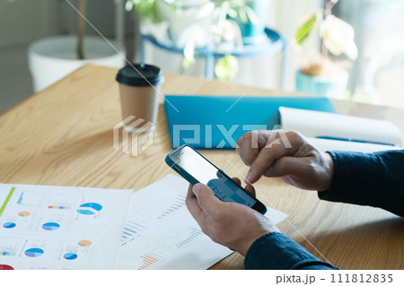 スマートフォンを操作する男性の手元 111812835