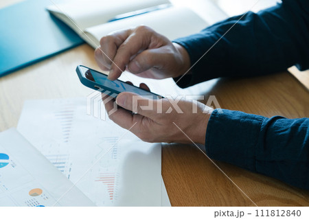 スマートフォンを操作する男性の手元 111812840