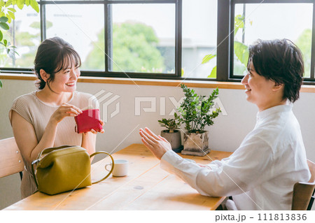 カフェ・レストラン・外食で会計時に自分の分の支払いを財布から出す女性と断る男性 111813836