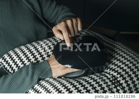 man uses a hand massager indoors 111818286