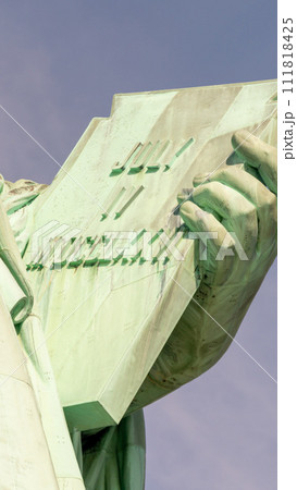 Declaration of Independence in the hand of the statue of liberty with the date of its adoption on July 4 111818425