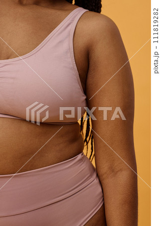 Conceptual studio shot of body part of unrecognizable young Black woman in comfortable pale pink underwear 111819282