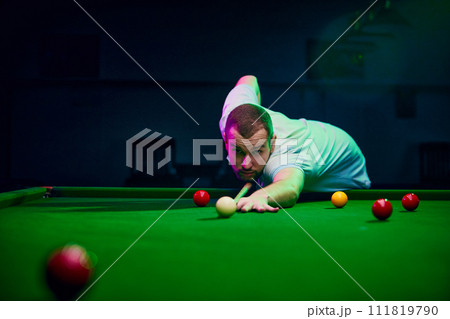 Dynamic shot of a player making shot, expressing energy and excitement for promoting billiards championship and local tournaments. Snooker game Dynamic shot of a player making shot, expressing energy and excitement for promoting billiards championship and local tournaments. Snooker game 111819790