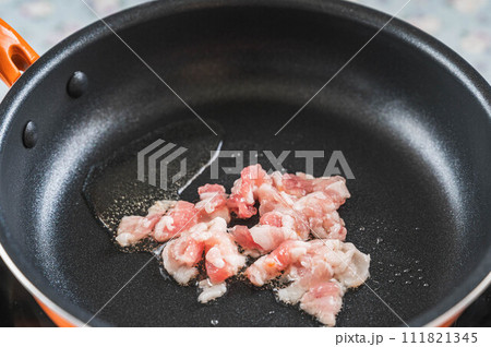フライパンで炒める豚肉 111821345