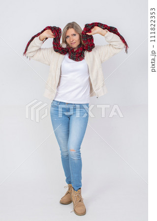Full length beautiful adult woman wearing blue jeans and a warm sweater on a gray background. 111822353