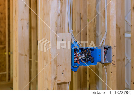 Electrical switch box is plastic wires attached to its wooden frame beams 111822706