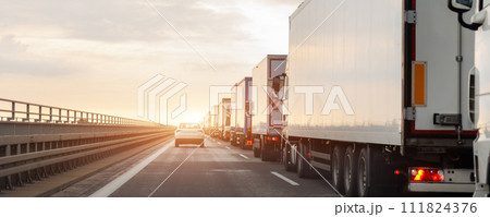 Queue of Trucks on Ukraine-Poland Border traffic jam at Sunset During Protest Roadblock. Business agricultural Logistics blockade action. Cargo lorry semi-trailers stuck Queue of Trucks on Ukraine-Poland Border traffic jam at Sunset During Protest Roadblock. Business agricultural Logistics blockade action. Cargo lorry semi-trailers stuck 111824376