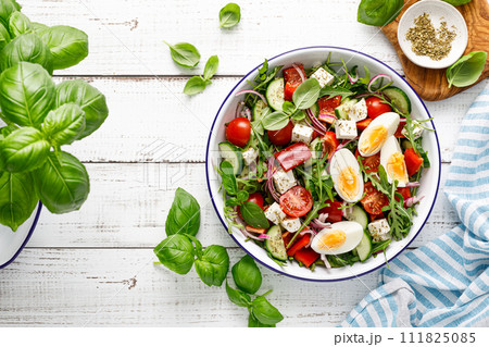 Egg and arugula fresh vegetable salad with feta cheese, top view Egg and arugula fresh vegetable salad with feta cheese, top view 111825085