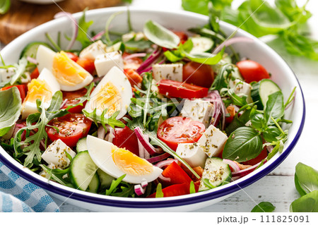 Egg and arugula fresh vegetable salad with feta cheese 111825091