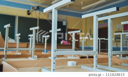 The concept of graduating from high school. Upside-down chairs in an empty classroom at the school. The concept of graduating from high school. Upside-down chairs in an empty classroom at the school. 111828615