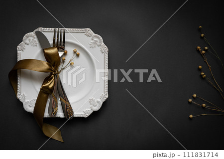 Romantic tabble setting with ribbon, plates, cutlery on black background. Empty plate. Mockup design layout for your text. Love romantic concept. Copy space. Top view. Flat lay. 111831714