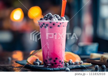 AI-generated content. Pink bubble tea with blueberries, in a transparent glass with a red straw, on a table with a blurred background 111832010