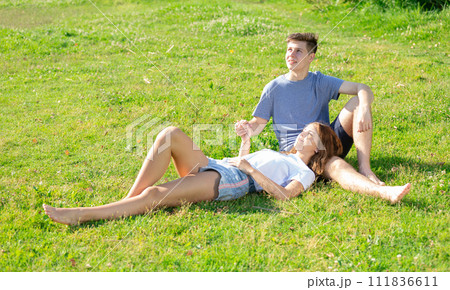 Happy romantic couple sitting on grass in day 111836611