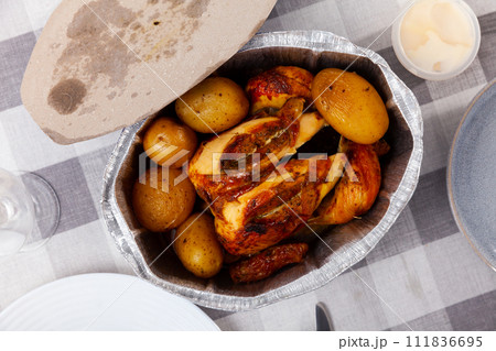 on table in baking dish is ready-to-eat fried chicken with potatoes in skin on table in baking dish is ready-to-eat fried chicken with potatoes in skin 111836695