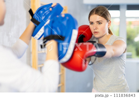 Teen girl in punch mitts boxing 111836843