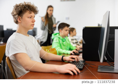 Portrait of guy working at computer in computer class at school Portrait of guy working at computer in computer class at school 111837238