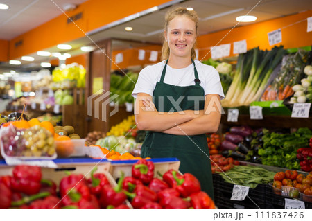 Portrait of a smiling girl who works part-time in a store as a trainee saleswoman 111837426