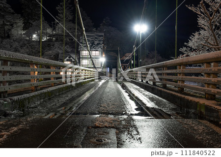 湿った雪で滑りやすい夜の橋 111840522