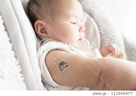右腕に注射跡の絆創膏を貼っている生後半年のハーフの男の子赤ちゃん 右腕に注射跡の絆創膏を貼っている生後半年のハーフの男の子赤ちゃん 111840977