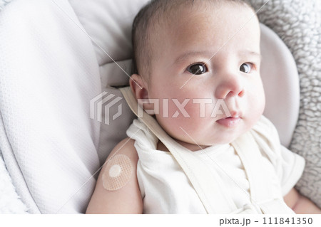 右腕に注射跡の絆創膏を貼っている生後半年のハーフの男の子赤ちゃん 右腕に注射跡の絆創膏を貼っている生後半年のハーフの男の子赤ちゃん 111841350