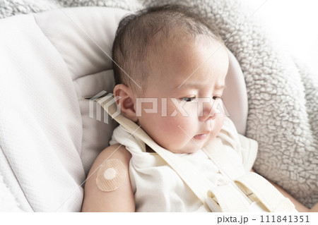 右腕に注射跡の絆創膏を貼っている生後半年のハーフの男の子赤ちゃん 111841351