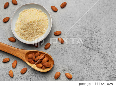 Fresh almond flour in a bowl and almonds Fresh almond flour in a bowl and almonds 111841829