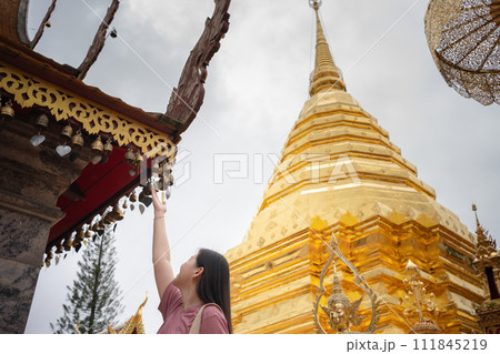 asian woman travel and touch to small bell in temple at chiangmai  Thailand in summer season 111845219