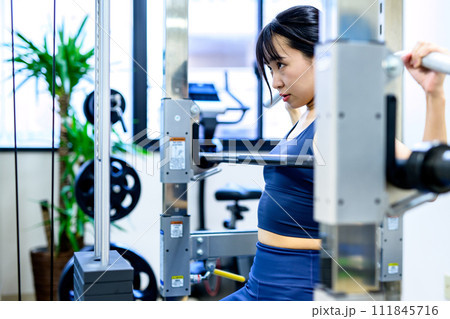 ジムで体を鍛える女性　疲労感　ラットプルダウン　筋トレ女子の横顔　ワークアウト　くっきり 111845716