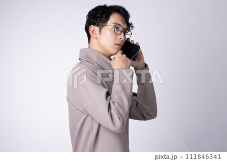 眼鏡をかけた若い男性のスマホでの会話イメージ 111846341