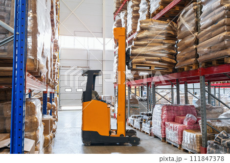 Forklift in a food warehouse loading goods onto a rack, warehouse logistics Forklift in a food warehouse loading goods onto a rack, warehouse logistics 111847378