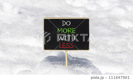 Do more with less symbol. Concept word Do more with less on beautiful black chalk blackboard. Beautiful white snow background. Business do more with less concept. Copy space. Do more with less symbol. Concept word Do more with less on beautiful black chalk blackboard. Beautiful white snow background. Business do more with less concept. Copy space. 111847901