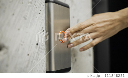 Female hand pressing elevator button, woman in office building, destination Female hand pressing elevator button, woman in office building, destination 111848221