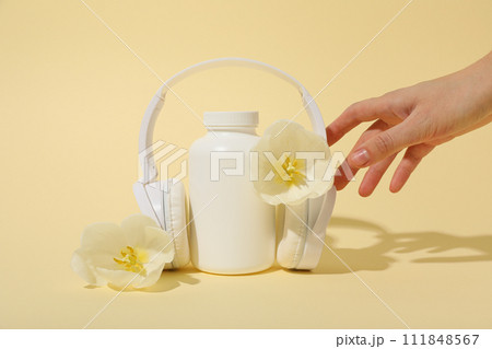 A bottle with bio-additives, with flowers, on a light background. 111848567