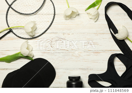 Sports accessories with spring flowers, on a light background. Sports accessories with spring flowers, on a light background. 111848569