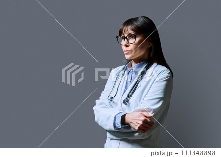 Serious mature woman doctor, profile view, gray background, copy space 111848898