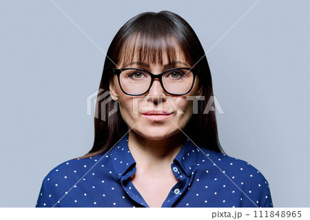 Headshot portrait of serious business mature woman with on grey background 111848965