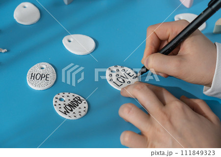 Master class writing word LOVE on EASTER egg Unrecognizable artist do it yourself air dry clay crafts for Easter holiday. Decoration gift idea Handmade children craft. Step by step instruction of 111849323