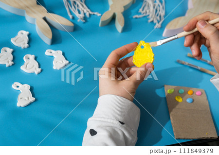 Master class of coloring Creator is using white air dry clay for making decor to EASTER holiday. Creating hobby recreation activity that involves fingers. DIY crafting 111849379