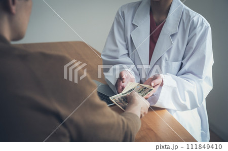 医師にお金を渡す患者 111849410