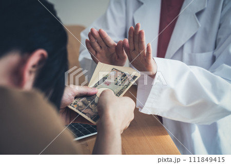 患者からお金を受け取るのを拒否する医師 111849415